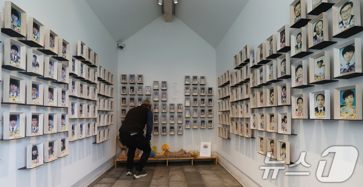 (서울=뉴스1) 오대일 기자 = 세월호 참사 12주기를 하루 앞둔 15일 오후 서울 중구 서울시의회 본관 앞에 마련된 세월호 기억공간에서 관계자가 희생자들의 영정이 놓인 추모 공간 …