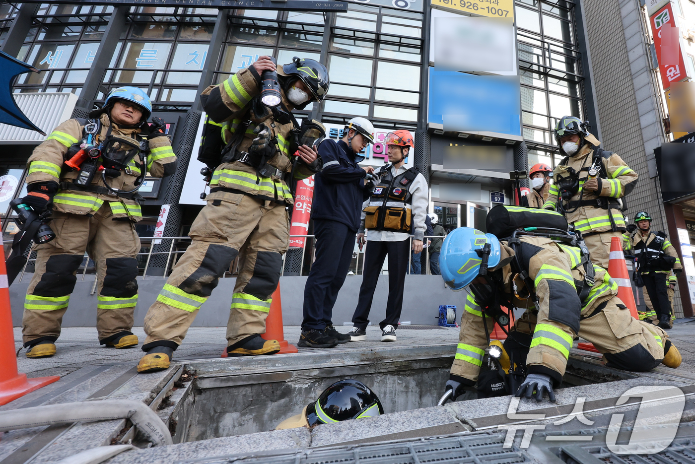 (서울=뉴스1) 김진환 기자 = 성북소방서 대원들이 16일 오전 화재가 발생한 서울 지하철 4호선 성신여대입구역 전력구 내부로 진입하고 있다. 2026.4.16/뉴스1