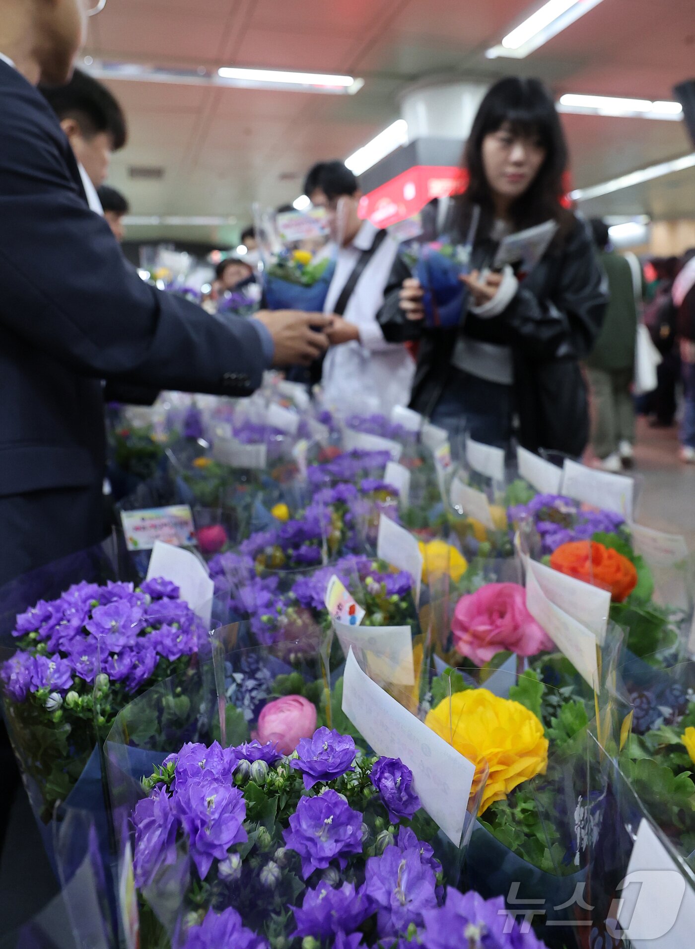 본문 이미지 - 16일 오전 서울 종로구 광화문역 대합실에서 서울교통공사 관계자들이 시민들에게 꽃 화분 무료 나눔 행사를 하고 있다. 2026.4.16 ⓒ 뉴스1 김성진 기자