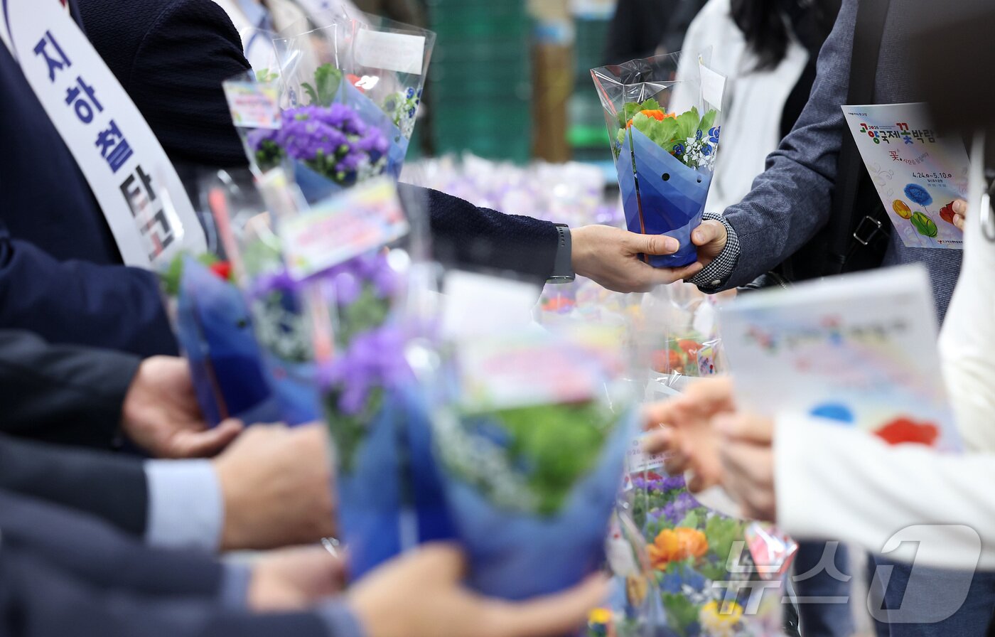 본문 이미지 - 16일 오전 서울 종로구 광화문역 대합실에서 서울교통공사 관계자들이 시민들에게 꽃 화분 무료 나눔 행사를 하고 있다. 이번 행사는 고양국제박람회재단과 함께 마련한 것으로, 출근길 시민들에게 봄의 정취를 전하고 대중교통 이용을 유도하기 위해 기획됐다. 2026 고양국제꽃박람회는 오는 24일부터 5월 10일까지 일산호수공원에서 진행된다. 2026.4.16 ⓒ 뉴스1 김성진 기자