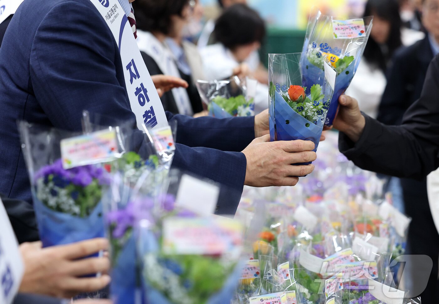 본문 이미지 - 16일 오전 서울 종로구 광화문역 대합실에서 서울교통공사 관계자들이 시민들에게 꽃 화분 무료 나눔 행사를 하고 있다. 2026.4.16 ⓒ 뉴스1 김성진 기자