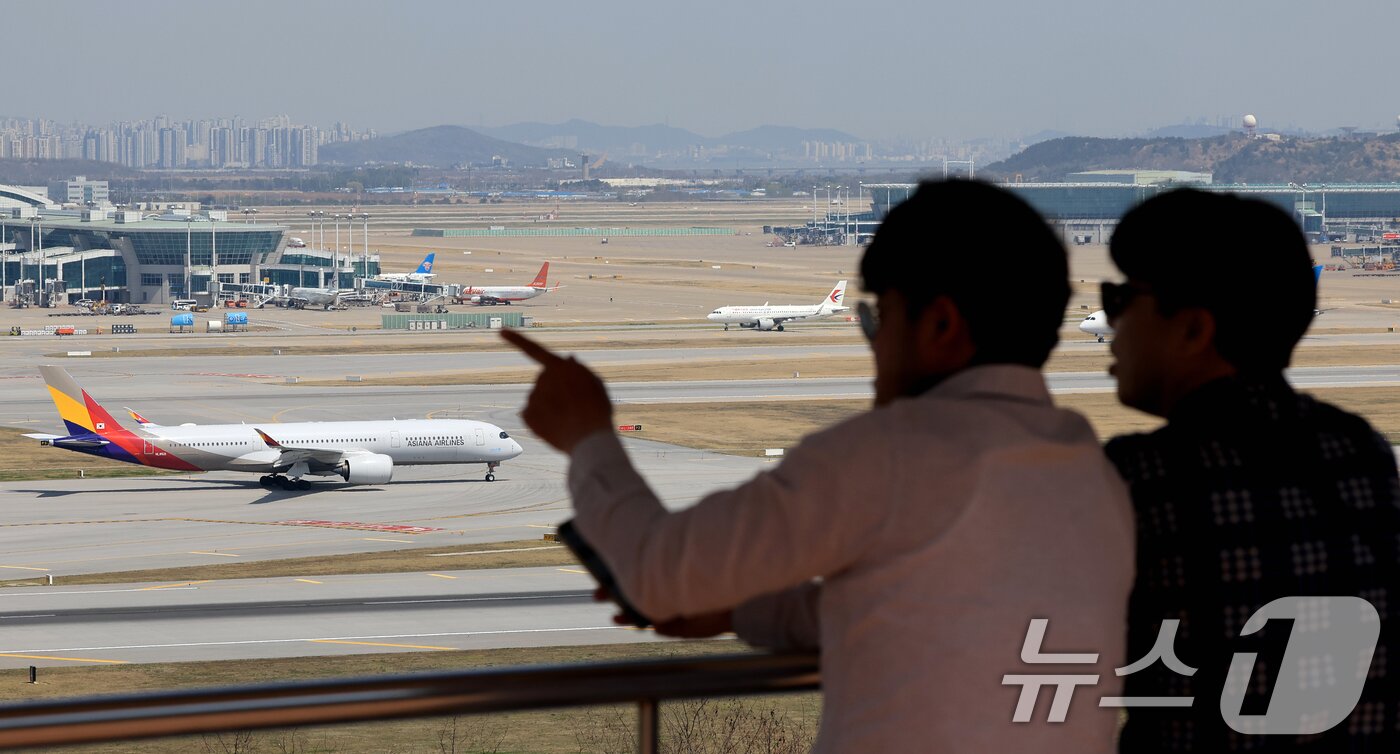 본문 이미지 - 중동 사태에 장기화로 국제선 항공권의 유류할증료가 사상 최고 수준으로 치솟은 16일 인천국제공항 전망대를 찾은 시민들이 항공기를 바라보고 있다.  2026.4.16 ⓒ 뉴스1 이호윤 기자
