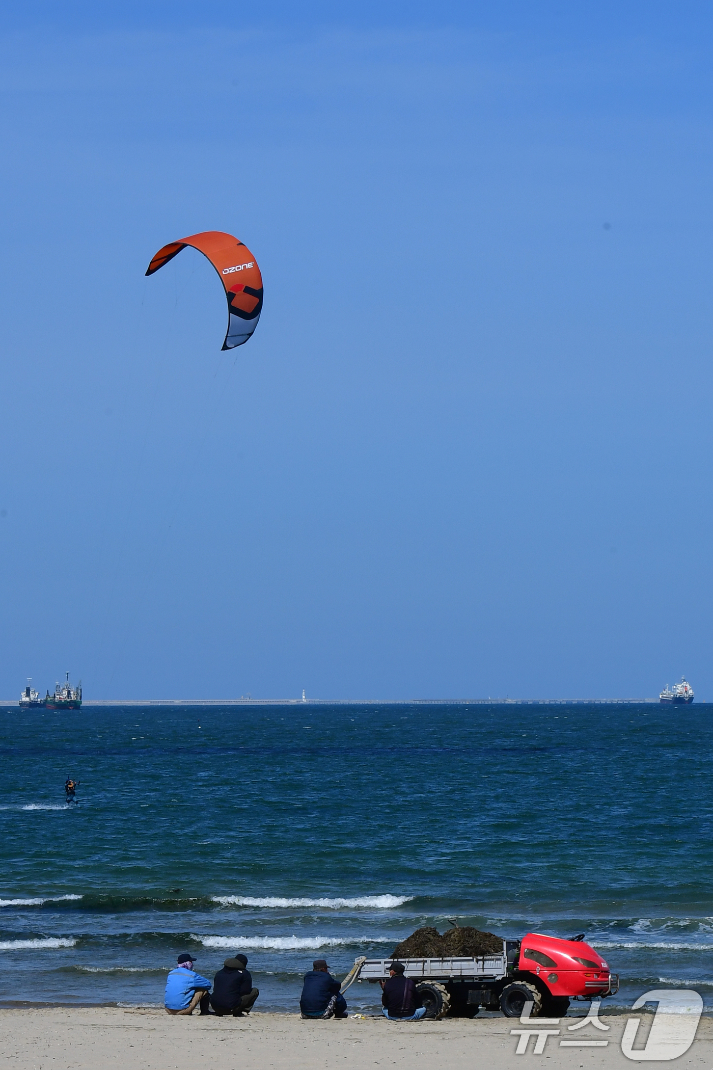 (포항=뉴스1) 최창호 기자 = 16일 오후 경북 포항시 송도해수욕장에서 백사장에서 공공근로자들이 수면 위를 달리는 카이트 보드를 지켜보고 있다.  2026.4.16/뉴스1