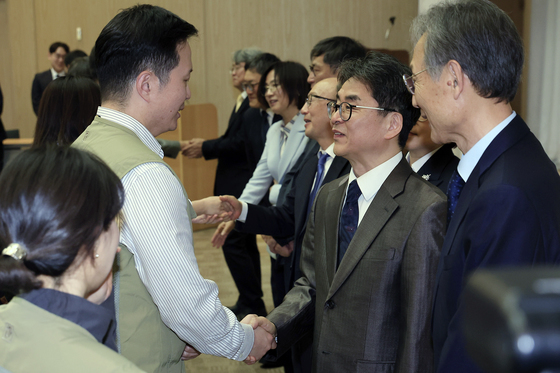 김우석 상임위원, 사과 등 입장 표명 요구 노조 지부장과 악수