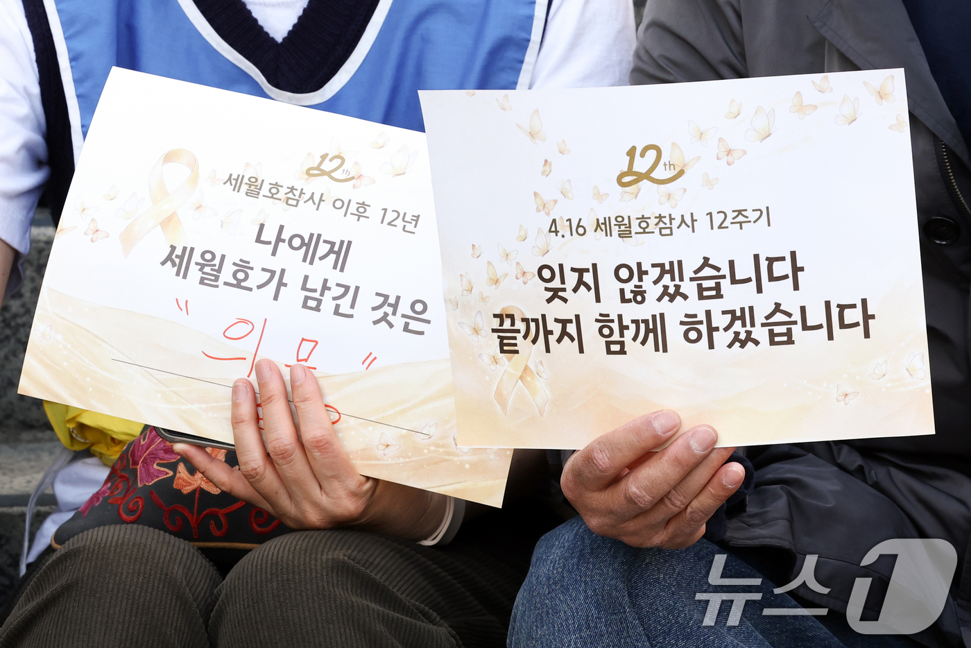 (서울=뉴스1) 최지환 기자 = 16일 서울 중구 세월호 기억공간 '기억과 빛' 앞에서 열린 세월호 참사 12주기 시민 기억식에서 시민들이 손팻말을 들고 있다. 2026.4.16/ …