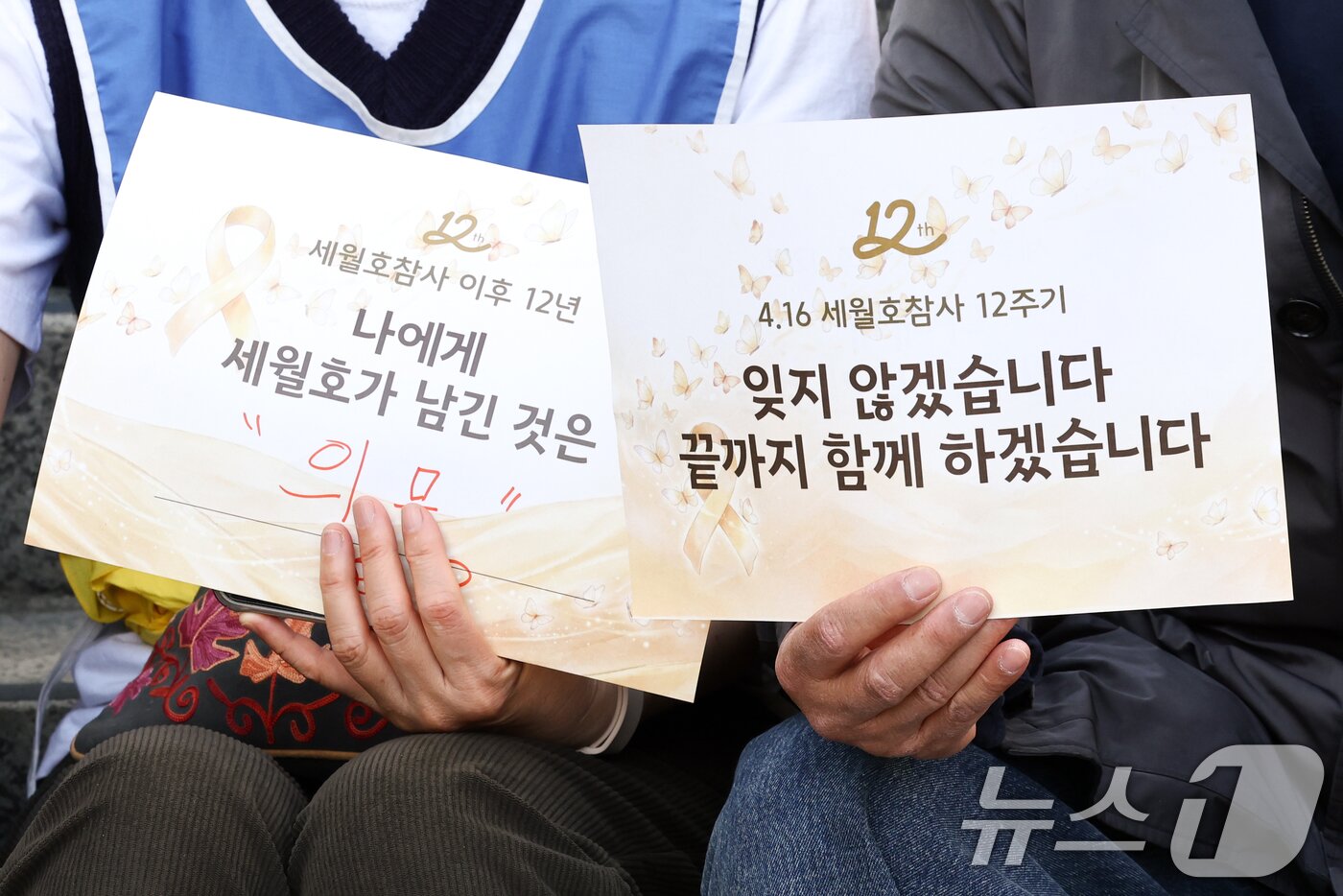 본문 이미지 - 16일 서울 중구 세월호 기억공간 '기억과 빛' 앞에서 열린 세월호 참사 12주기 시민 기억식에서 시민들이 손팻말을 들고 있다. 2026.4.16 ⓒ 뉴스1 최지환 기자