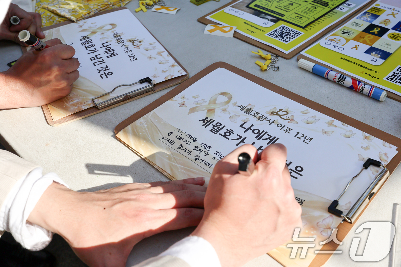 (서울=뉴스1) 최지환 기자 = 16일 오후 서울 중구 세월호 기억공간에서 열린 세월호참사 12주기 세월호 기억공간 시민 기억식을 앞두고 추모객들이 추모 문구를 작성하고 있다. 2 …