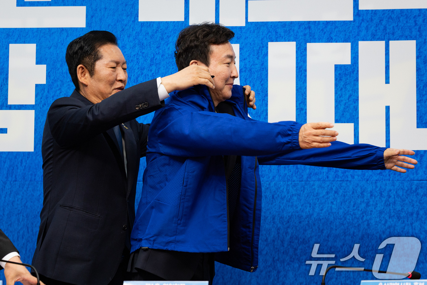 (서울=뉴스1) 유승관 기자 = 정청래 더불어민주당 대표가 17일 서울 여의도 국회에서 열린 제1차 인재영입식에서 전태진 변호사에게 당 점퍼를 입혀주고 있다. 2026.4.17/뉴 …