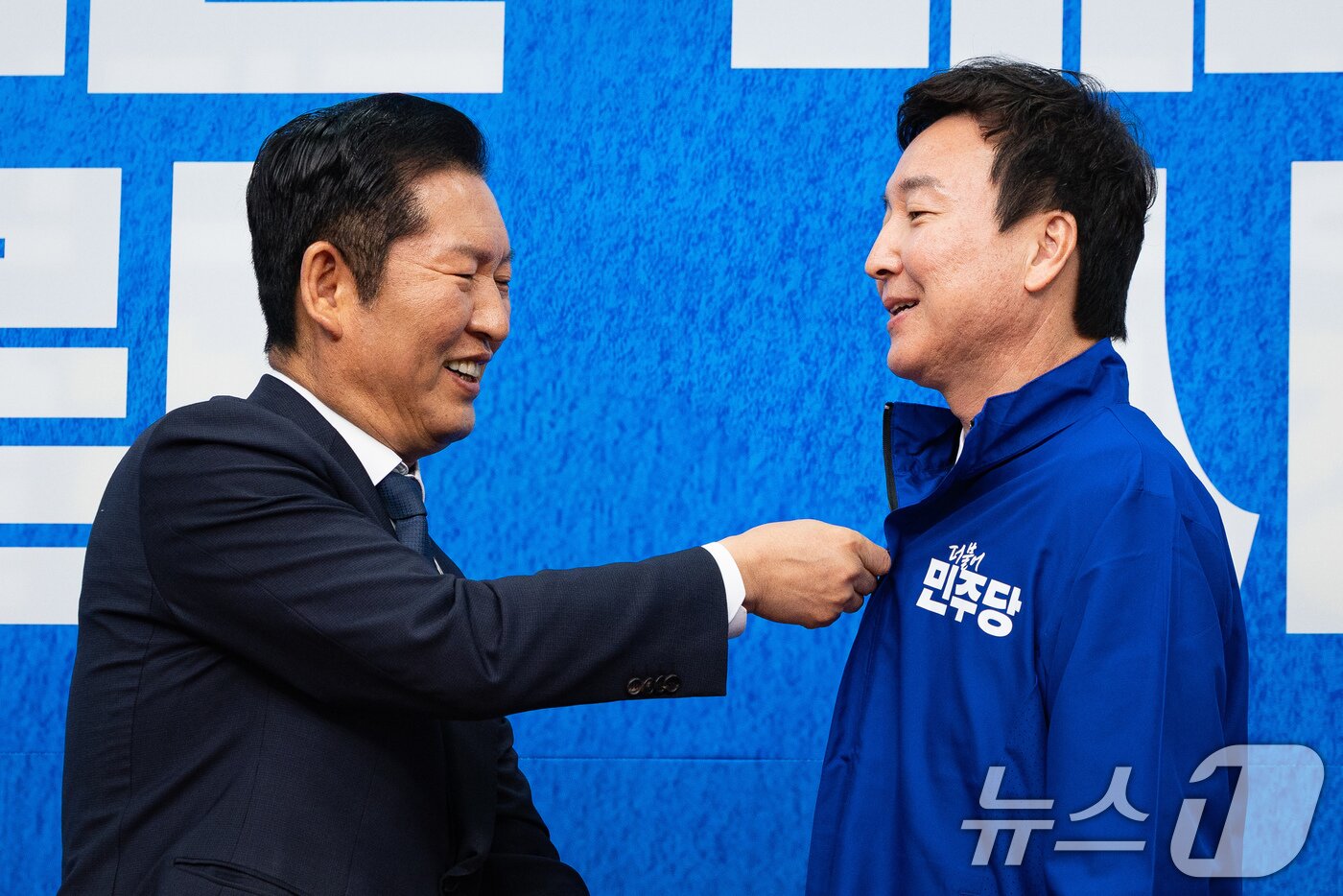 본문 이미지 - 정청래 더불어민주당 대표가 17일 서울 여의도 국회에서 열린 제1차 인재영입식에서 전태진 변호사에게 당 점퍼를 입혀주고 있다.  2026.4.17 ⓒ 뉴스1 유승관 기자