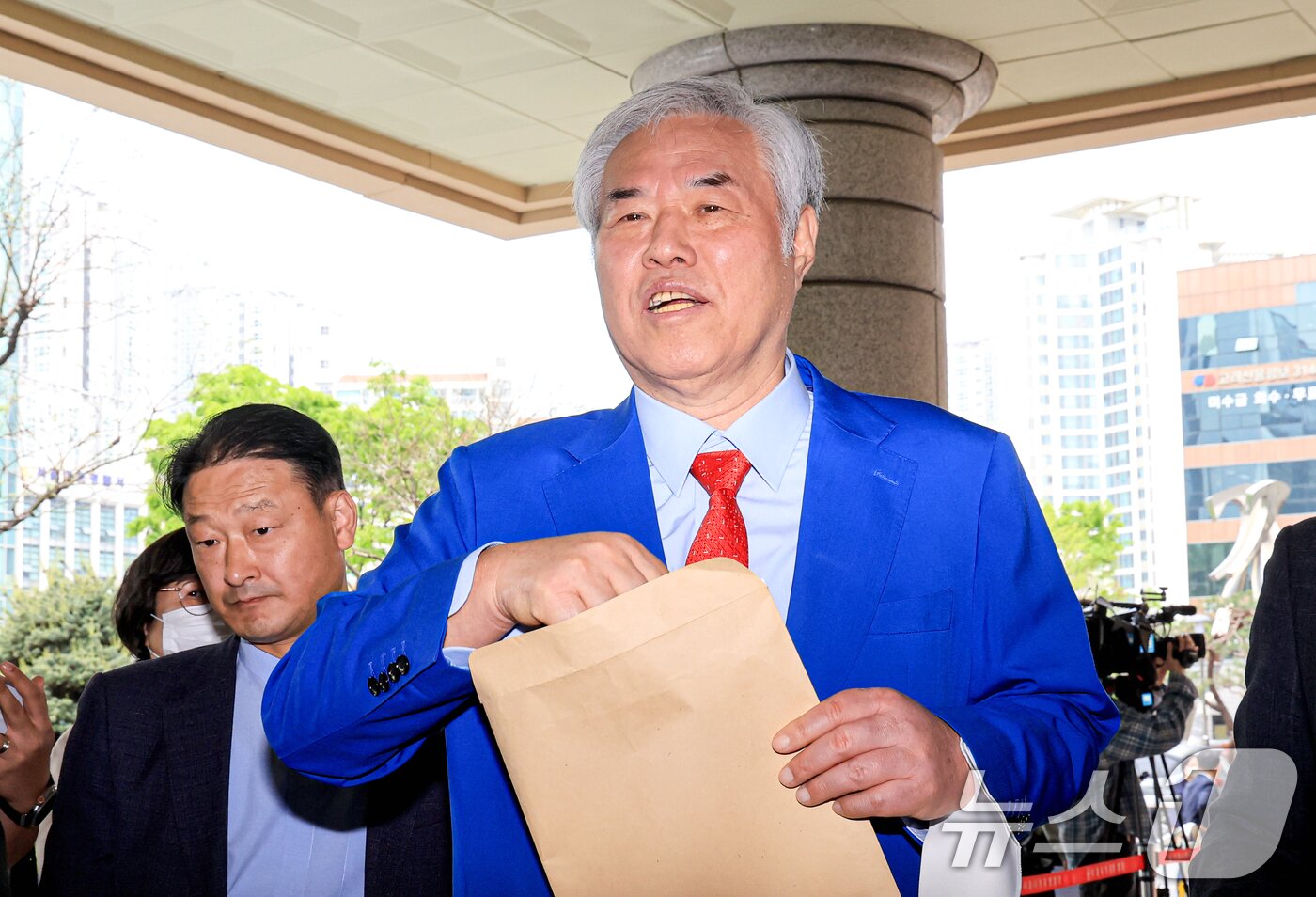 본문 이미지 - 서울서부지법 난동 사태 배후로 지목돼 수건조물침입교사 혐의 등으로 기소된 전광훈 사랑제일교회 목사가 17일 서울 마포구 서울서부지법에서 열린 재판을 마치고 입장문을 취재진에게 건네고 있다. 2026.4.17 ⓒ 뉴스1 이호윤 기자