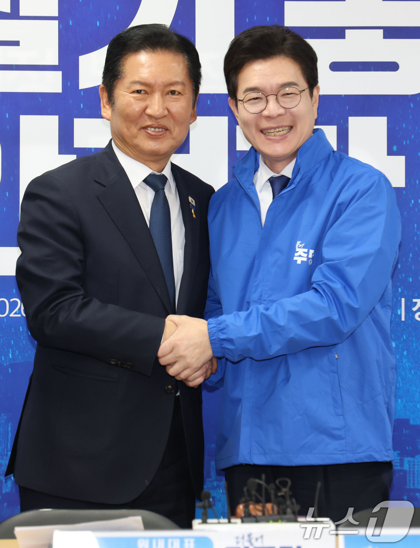 (서울=뉴스1) 이광호 기자 = 정청래 더불어민주당 대표가 17일 오전 서울 용산구 강태웅 용산구청장 후보 사무소에서 열린 현장 최고위원회의에서 정원오 서울시장 후보에게 당 점퍼를 …