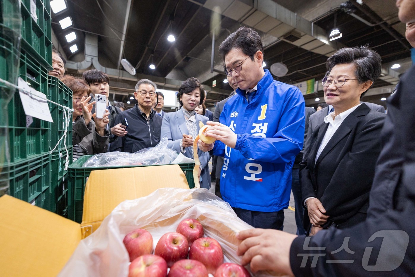 (서울=뉴스1) = 정원오 더불어민주당 서울시장 후보가 17일 서울 송파구 가락동 농수산물 시장을 방문해 사과를 깎고 있다. (정원오 캠프 제공. 재판매 및 DB 금지) 2026. …