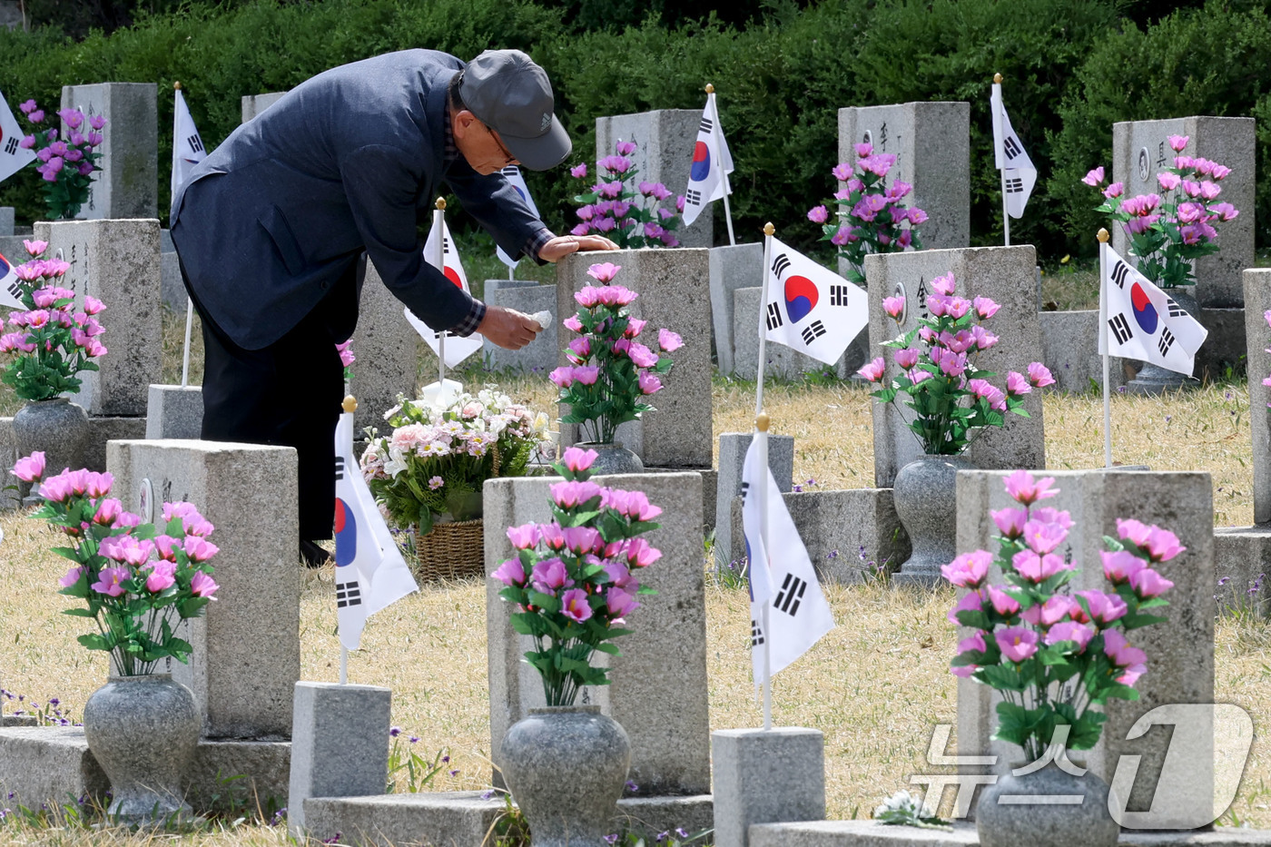 (서울=뉴스1) 이광호 기자 = 4.19혁명 기념일을 앞둔 17일 오후 서울 강북국 국립4.19 민주묘지를 찾은 유족이 묘비를 닦고 있다.  2026.4.17/뉴스1