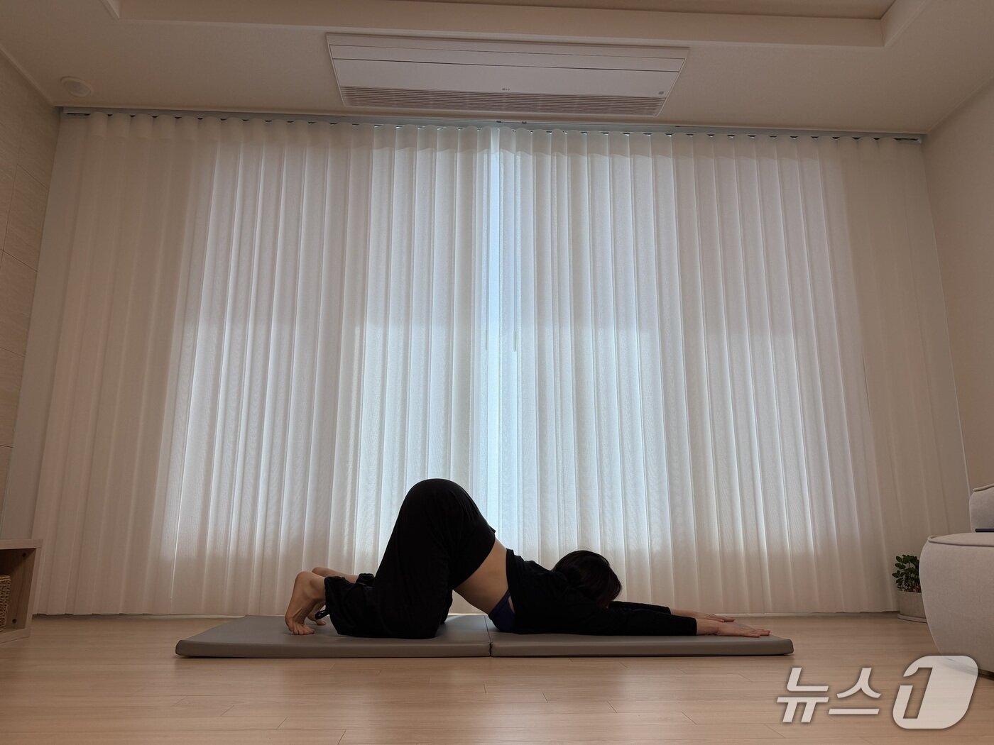 본문 이미지 - 김유빈 요가강사가 깊은 고양이자세를 선보이고 있다. 테이블 포즈에서 열 발가락을 꺾어 세우고 양손을 앞으로 길게 뻗어 가슴과 턱을 바닥으로 내린다. 등이 많이 굽어 가슴과 턱이 바닥에 닿지 않으면 이마를 바닥에 대고 유지한다. 날개뼈와 연결된 어깨와 척추를 함께 풀어준다. 어깨 및 등 상부 이완 효과가 있다.ⓒ 뉴스1 서장원 기자