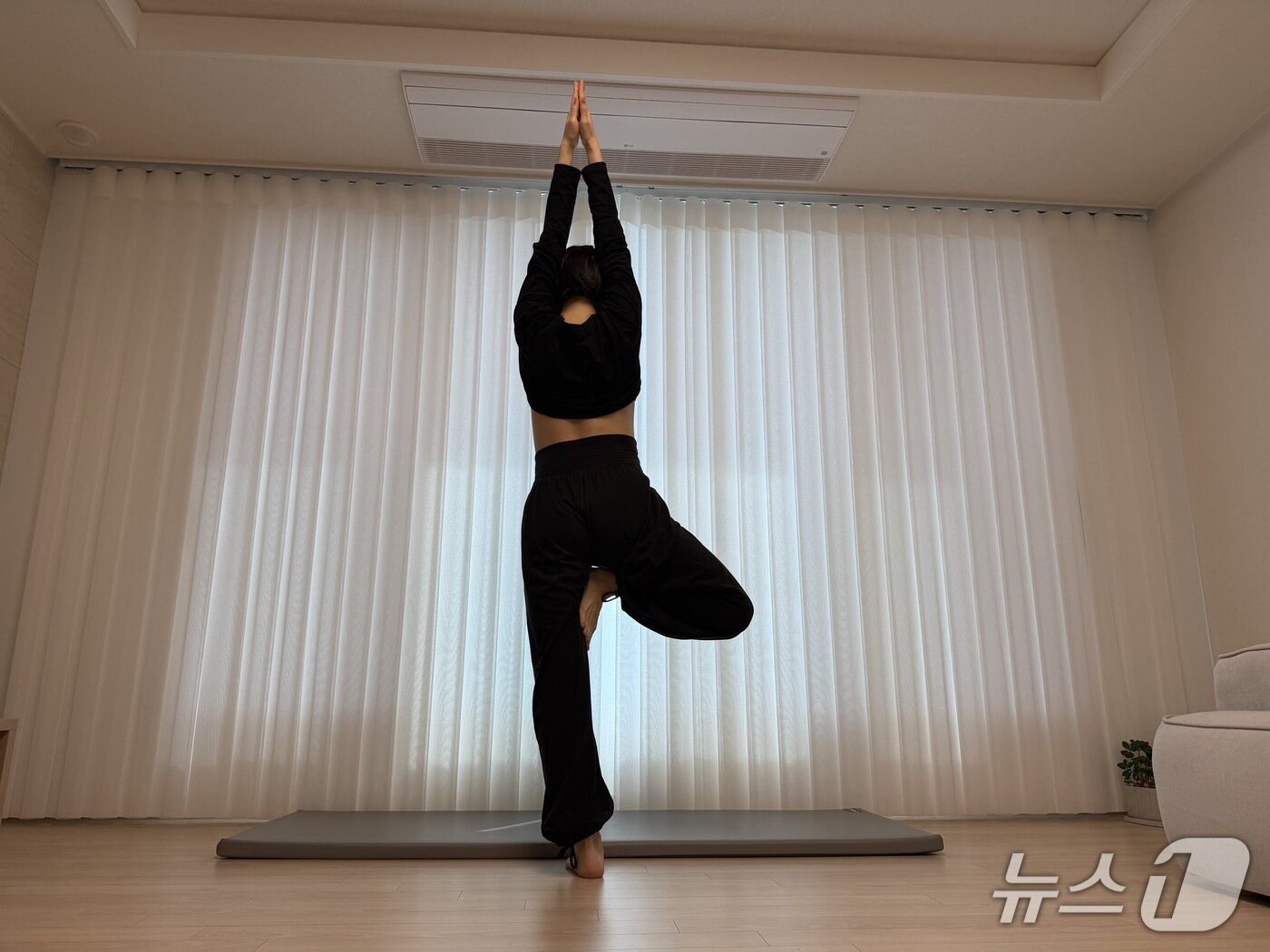 본문 이미지 - 김유빈 요가강사가 나무자세를 보여주고 있다. 고령자나 임신부는 넘어질 위험이 있어 반드시 벽이나 의자를 잡고 안전하게 수행한다. 균형 감각 및 하체 근력 강화에 도움을 준다.ⓒ 뉴스1 서장원 기자