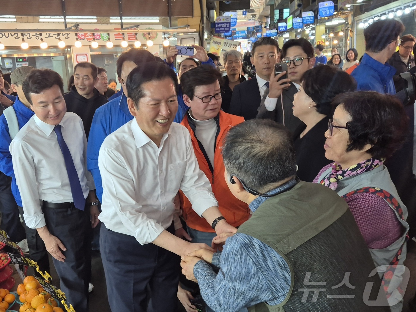 (울산=뉴스1) 박정현 기자 = 정청래 더불어민주당 대표 18일 울산 남구 신정시장의 한 과일가게에서 상인들과 악수하고 있다. 2026.4.18/뉴스1