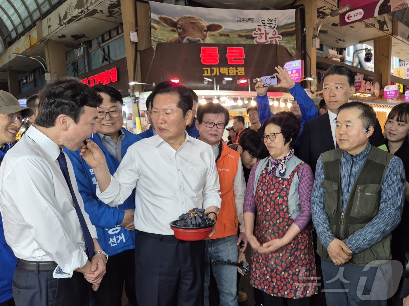 (울산=뉴스1) 박정현 기자 = 정청래 더불어민주당 대표 18일 울산 남구 신정시장의 한 과일가게에서 울산 남구갑 보궐선거 출마 예정자인 전태진 변호사에게 포도를 먹여주고 있다. …