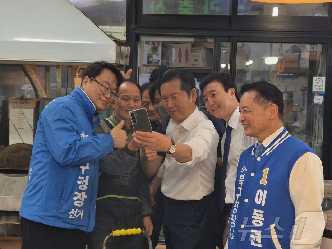 (울산=뉴스1) 박정현 기자 = 정청래 더불어민주당 대표가 18일 울산 남구 신정시장에서 떡가게를 운영하는 가족과 사진을 찍고 있다. 2026.4.18/뉴스1