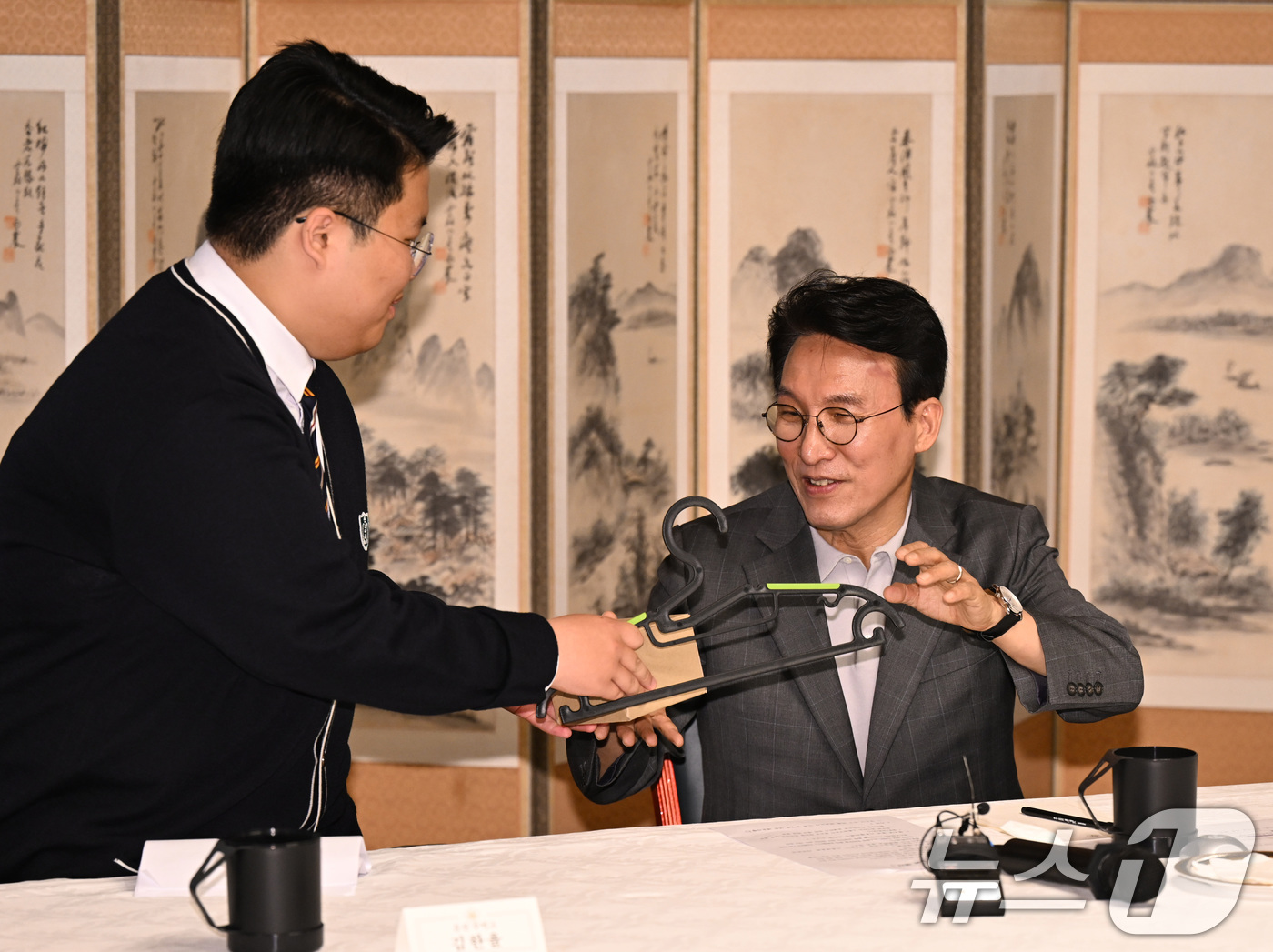 (서울=뉴스1) 김도우 기자 = 김민석 국무총리가 18일 서울 종로구 총리공관에서 열린 삼청동 오픈하우스 청소년·청년기후협의체와 간담회에서 참석한 학생에게 탄소중립 소재로 제작된 …