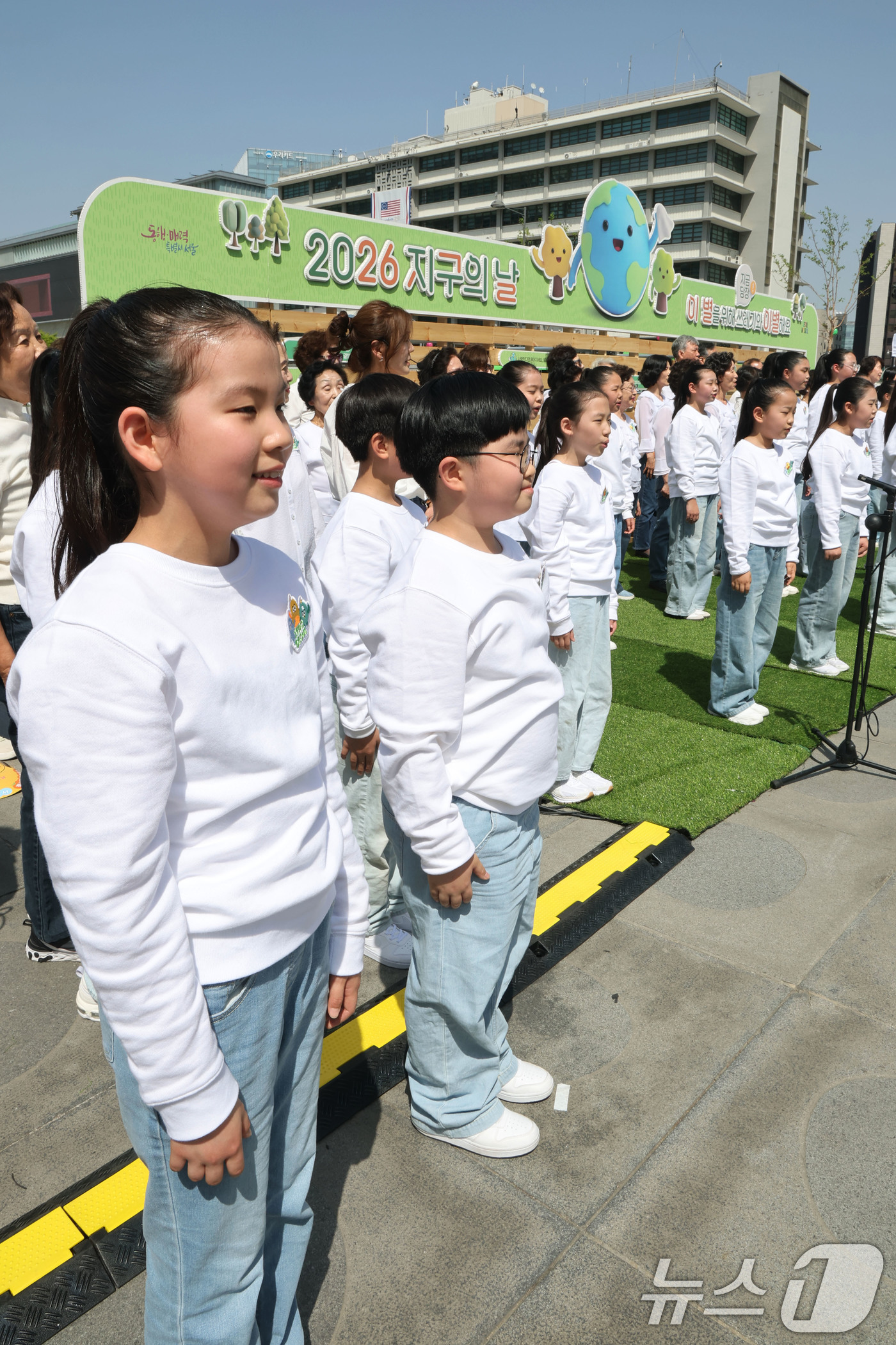 (서울=뉴스1) 이광호 기자 = 18일 오후 서울 종로구 광화문광장에서 열린 2026 지구의 날 기념식에서 남녀노소 117명의 시민들로 구성된 합창단이 케이팝 데몬헌터스의 ‘골든’ …