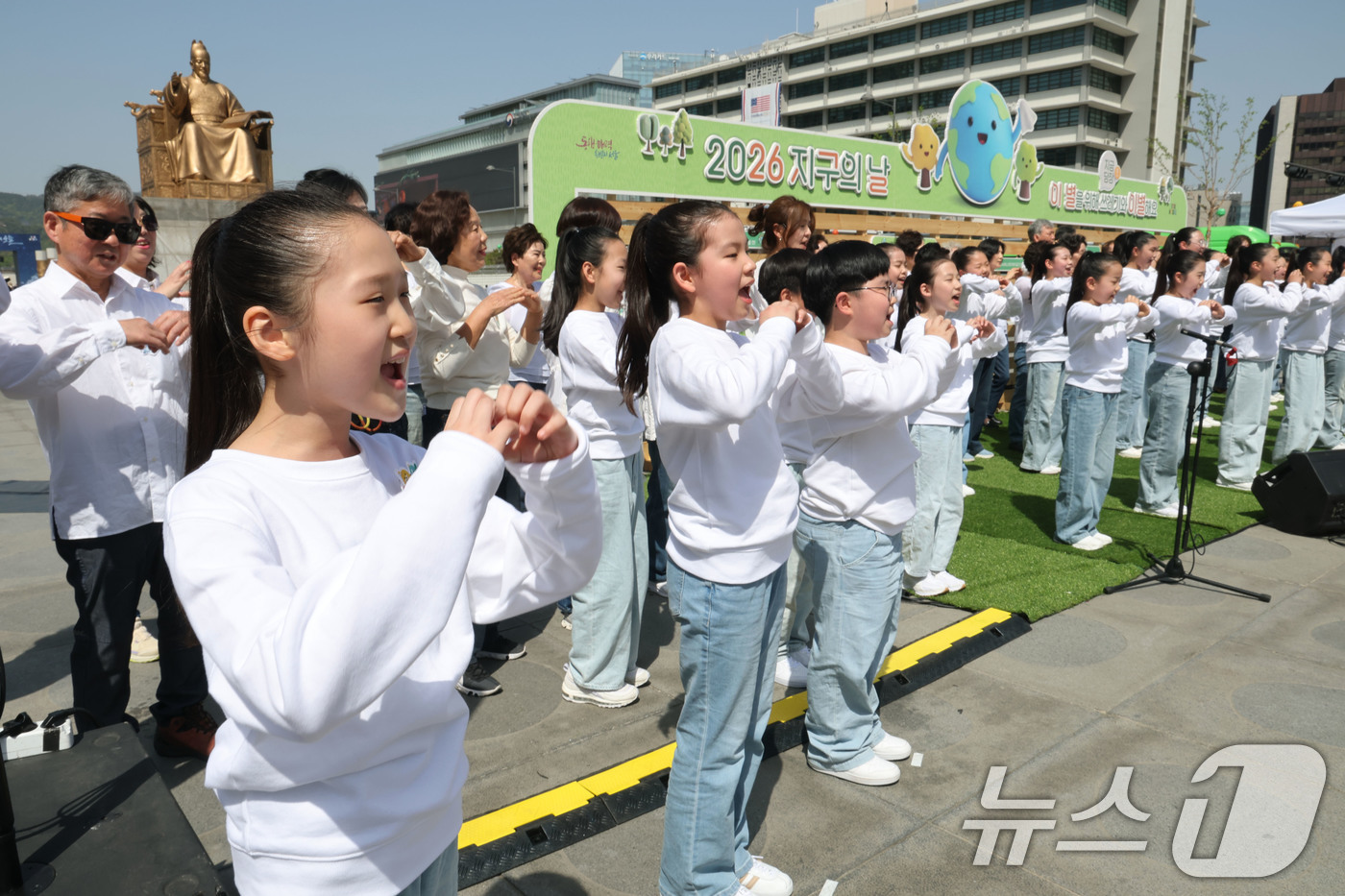 (서울=뉴스1) 이광호 기자 = 18일 오후 서울 종로구 광화문광장에서 열린 2026 지구의 날 기념식에서 남녀노소 117명의 시민들로 구성된 합창단이 케이팝 데몬헌터스의 ‘골든’ …