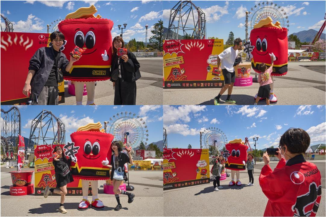 본문 이미지 - 후지큐 하이랜드 방문객들이 신라면 캐릭터 '신'(SHIN)과 기념사진을 찍고 있다.(농심 제공)
