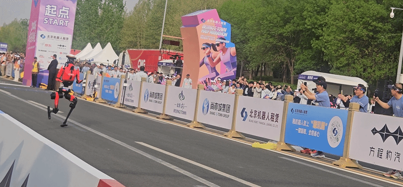 본문 이미지 -  아너의 로봇 산뎬이 19일 베이징에서 개최된 제2회 베이징 이좡 휴머노이드 로봇 하프마라톤 대회에서 출발선을 지나 질주하고 있다.