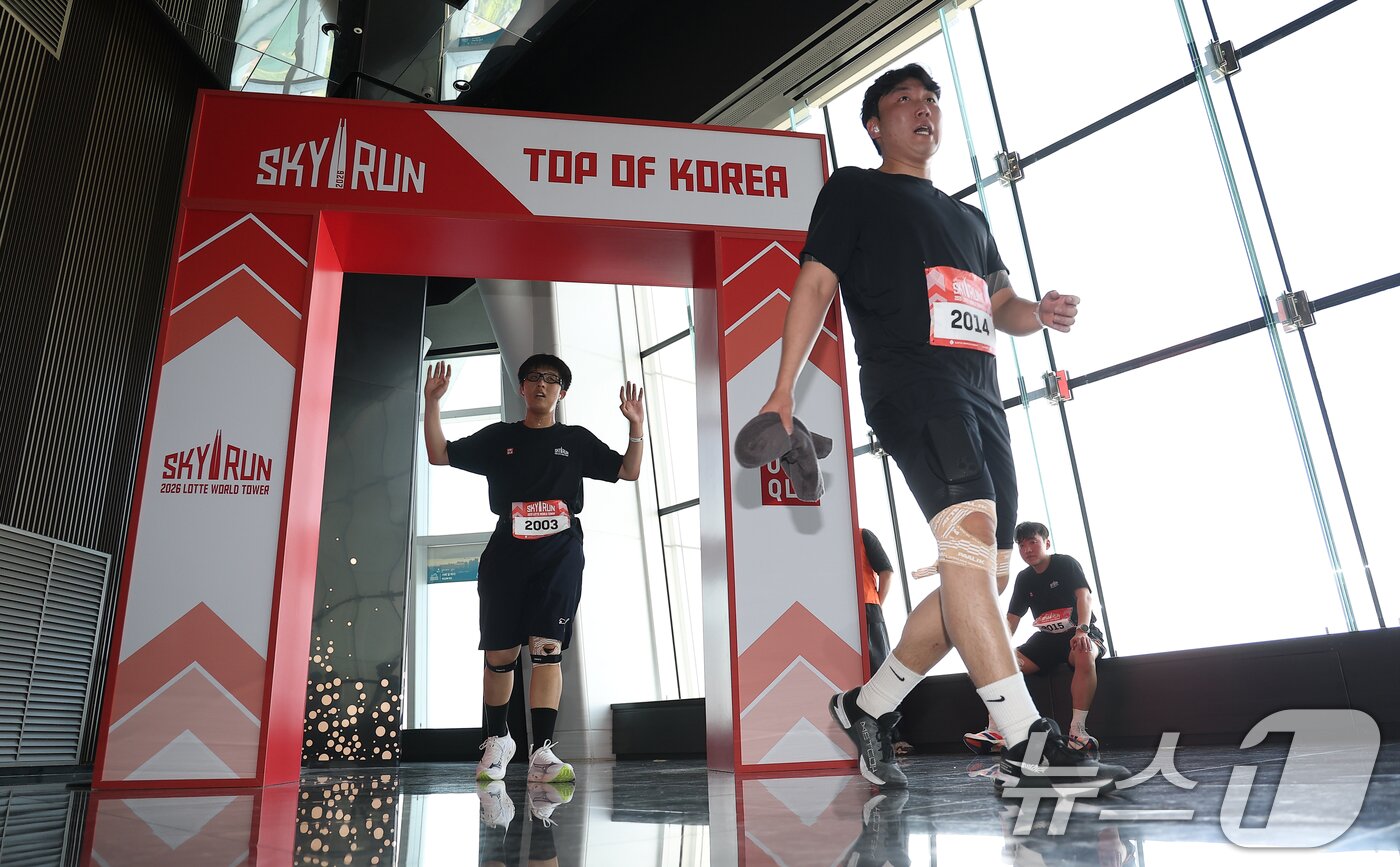 본문 이미지 - 19일 서울 송파구 롯데월드타워에서 열린 수직 마라톤 대회 '2026 롯데월드타워 스카이런' 행사에서 참가자들이 결승선을 지나고 있다.  (공동취재) 2026.4.19 ⓒ 뉴스1 황기선 기자