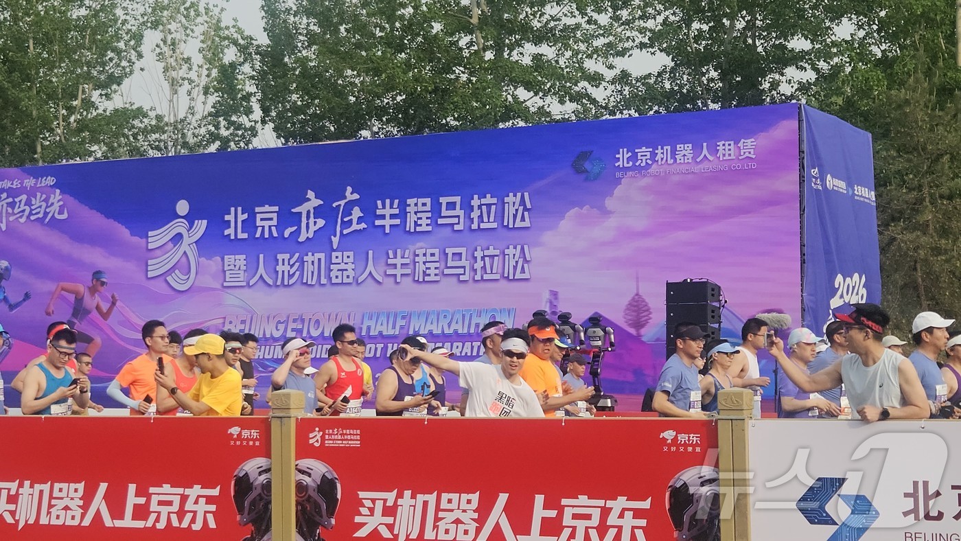 (베이징=뉴스1) 정은지 특파원 = 19일 오전 7시 30분 베이징에서 개최된 \'제2회 베이징 이좡 휴머노이드 로봇 하프마라톤\' 참가자들이 로봇들이 달리는 장면을 지켜보고 있다 …