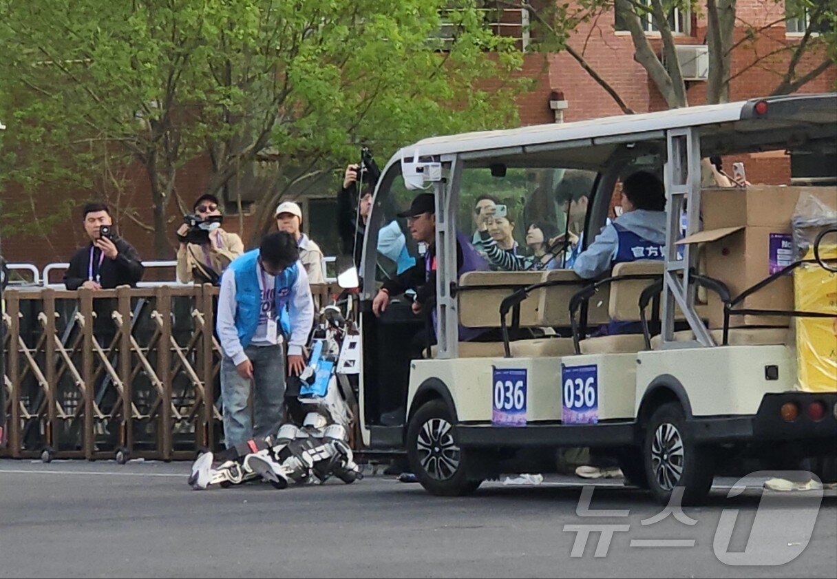 본문 이미지 - 19일 오전 베이징 이좡경제개발구에서 개최된 '제2회 베이징 이좡 휴머노이드 로봇 하프마라톤'에 참가한 로봇이 쓰러져있다. ⓒ 뉴스1 정은지 특파원