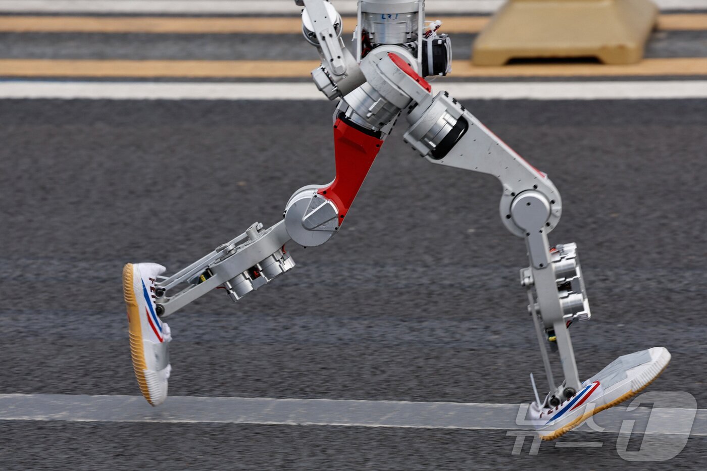 본문 이미지 - 19일 중국 베이징에서 열린 제2회 베이징 이타운 하프 마라톤 및 휴머노이드 로봇 하프 마라톤에서 휴머노이드 로봇이 달리고 있다. ⓒ 로이터=뉴스1