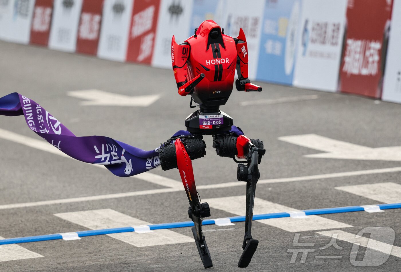 본문 이미지 - 19일 중국 베이징에서 열린 제2회 베이징 이타운 하프 마라톤 및 휴머노이드 로봇 하프 마라톤에서 휴머노이드 로봇이 결승선을 통과하고 있다. ⓒ 로이터=뉴스1