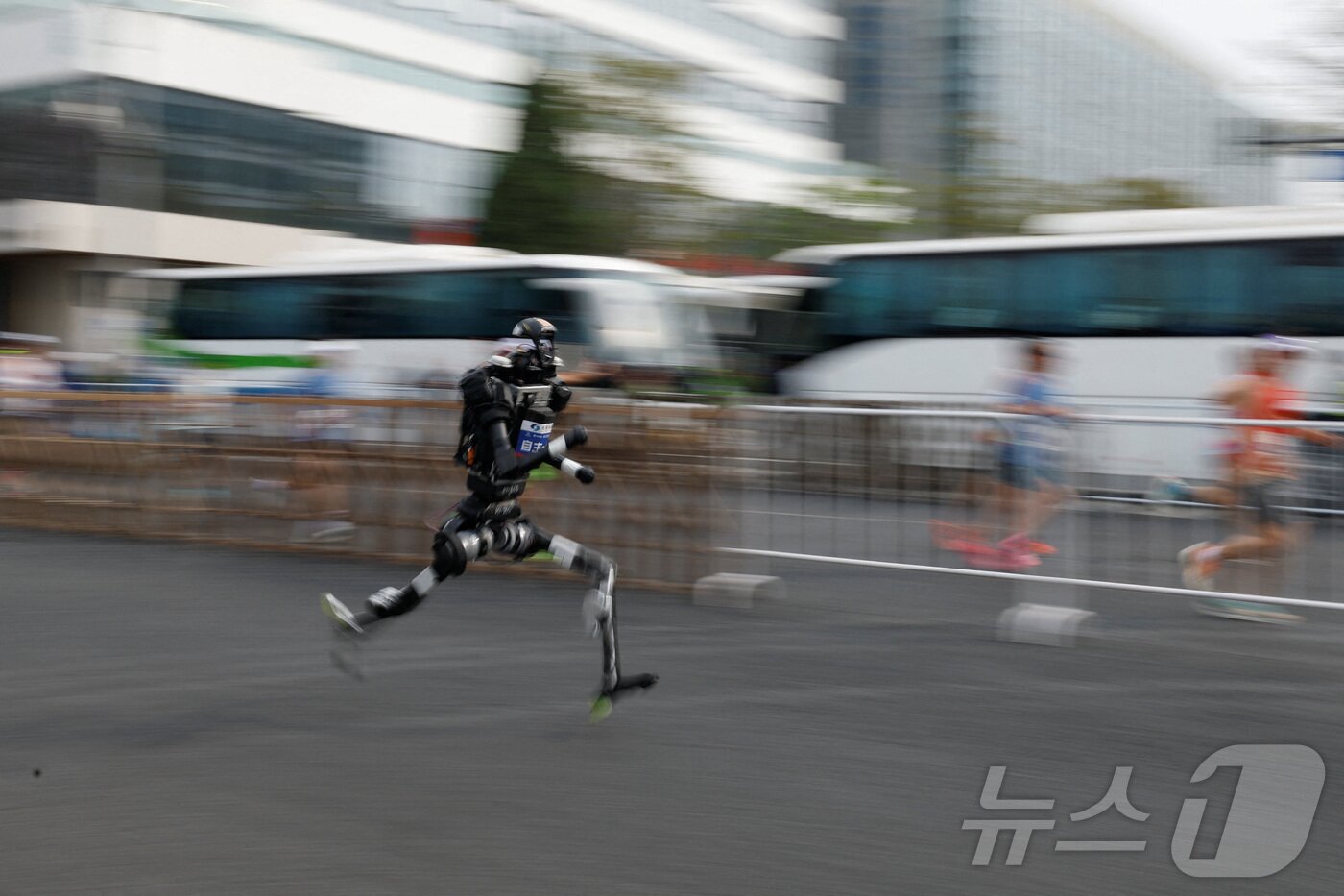 본문 이미지 - 19일 중국 베이징에서 열린 제2회 베이징 이타운 하프 마라톤 및 휴머노이드 로봇 하프 마라톤에서 휴머노이드 로봇이 달리고 있다. ⓒ 로이터=뉴스1