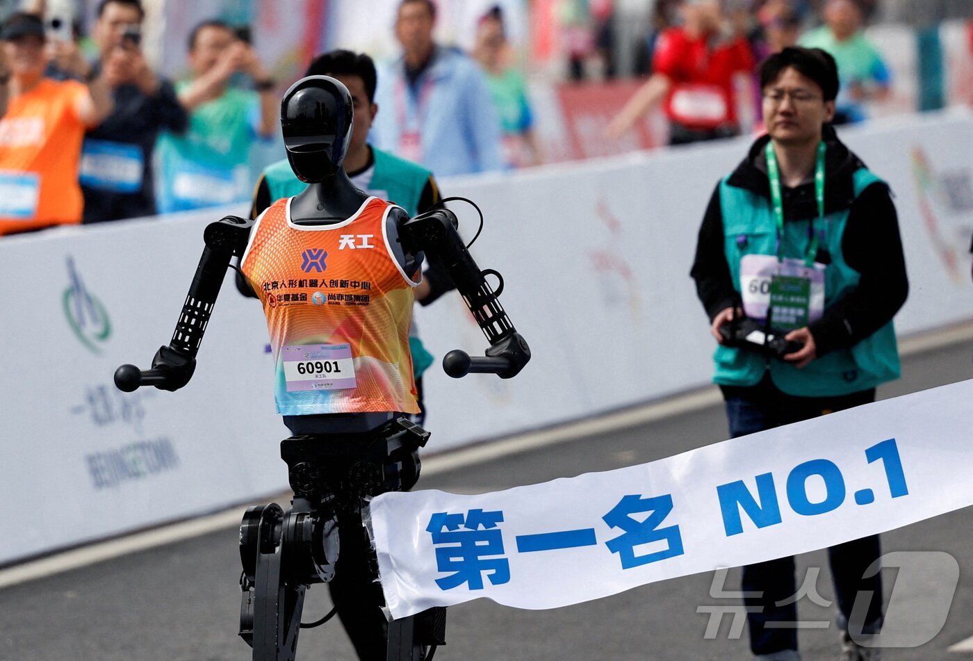 본문 이미지 - 2025년 4월19일 중국 베이징에서 열린 베이징 이타운 하프 마라톤 및 휴머노이드 로봇 하프 마라톤에서 휴머노이드 로봇 텐궁 울트라가 결승선을 통과하는 모습. ⓒ 로이터=뉴스1