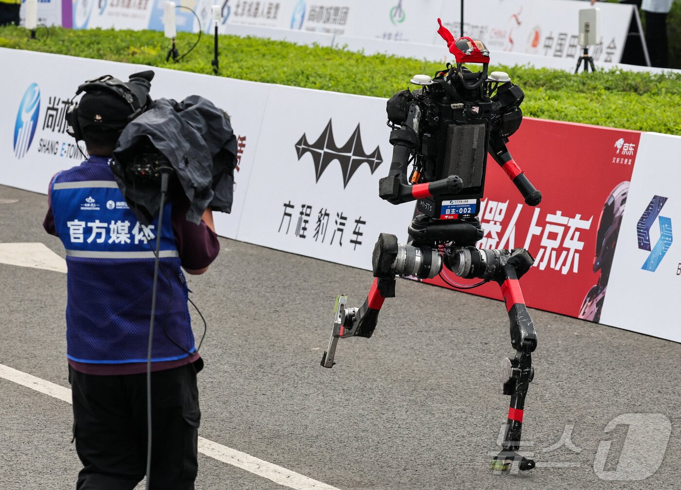 본문 이미지 - 19일 중국 베이징에서 열린 제2회 베이징 이타운 하프 마라톤 및 휴머노이드 로봇 하프 마라톤에서 휴머노이드 로봇이 달리고 있다. ⓒ 로이터=뉴스1