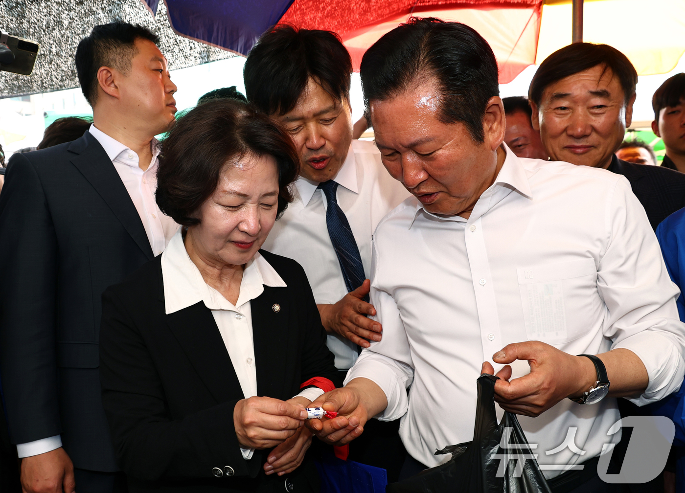 (성남=뉴스1) 이승배 기자 = 김용 전 민주연구원 부원장이 19일 오후 경기 성남시 모란시장 민속5일장에서 민생현장방문중인 정청래 대표에게 사탕을 달라고 말하고 있다. (공동취재 …