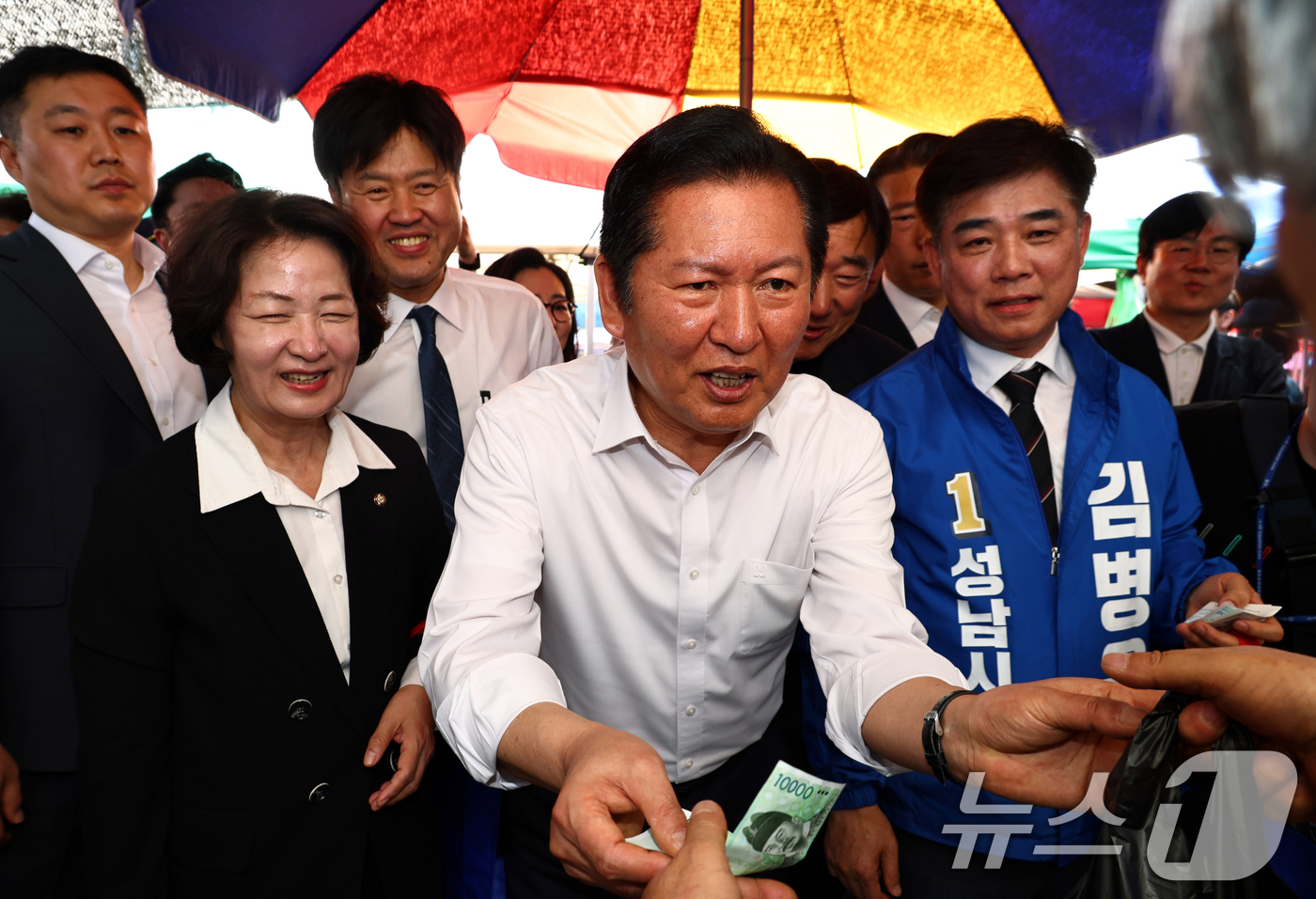 (성남=뉴스1) 이승배 기자 = 정청래 더불어민주당 대표가 19일 오후 경기 성남시 모란시장 민속5일장을 찾아 상인에게 사탕을 구매하고 있다. (공동취재) 2026.4.19/뉴스1 …