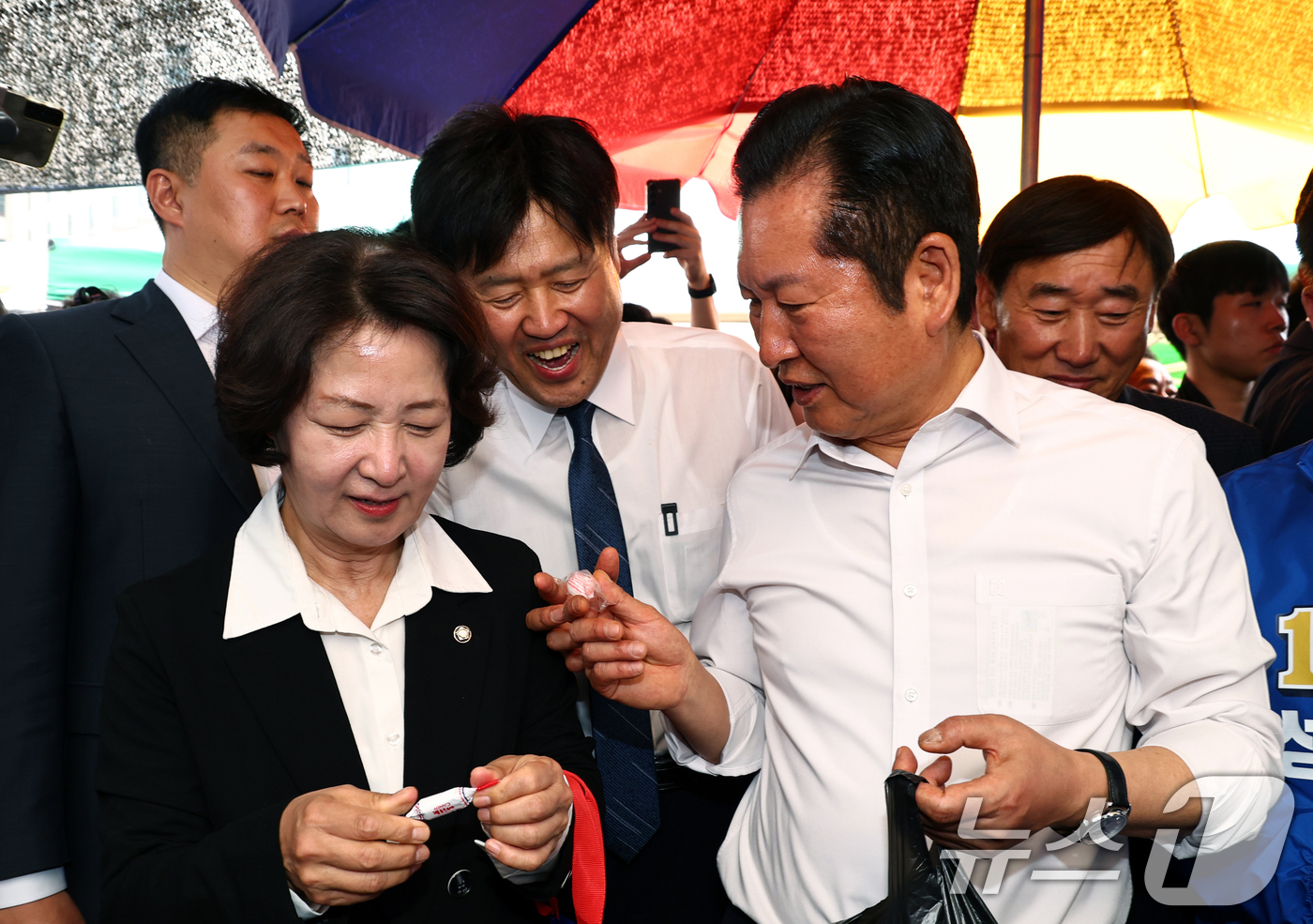 (성남=뉴스1) 이승배 기자 = 정청래 더불어민주당 대표가 19일 오후 경기 성남시 모란시장 민속5일장에서 김용 전 민주연구원 부원장에게 사탕을 전달하고 있다. (공동취재) 202 …