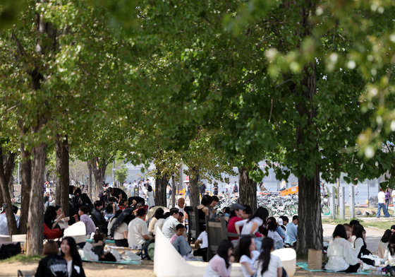 더위를 피해 나무 그늘 밑에 모인 시민들