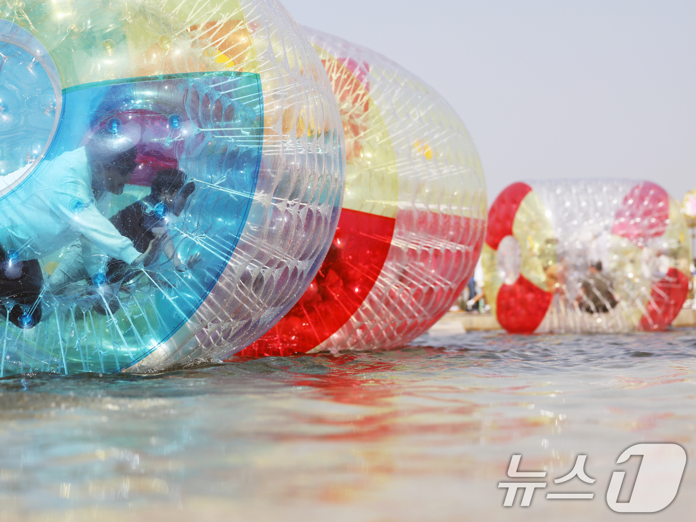 (서울=뉴스1) 황기선 기자 = 낮 기온이 전국 내륙을 중심으로 최고 29도로 치솟으며 초여름 날씨를 보인 19일 오후 서울 영등포구 여의도 한강공원 물빛광장에서 시민들이 워터볼 …