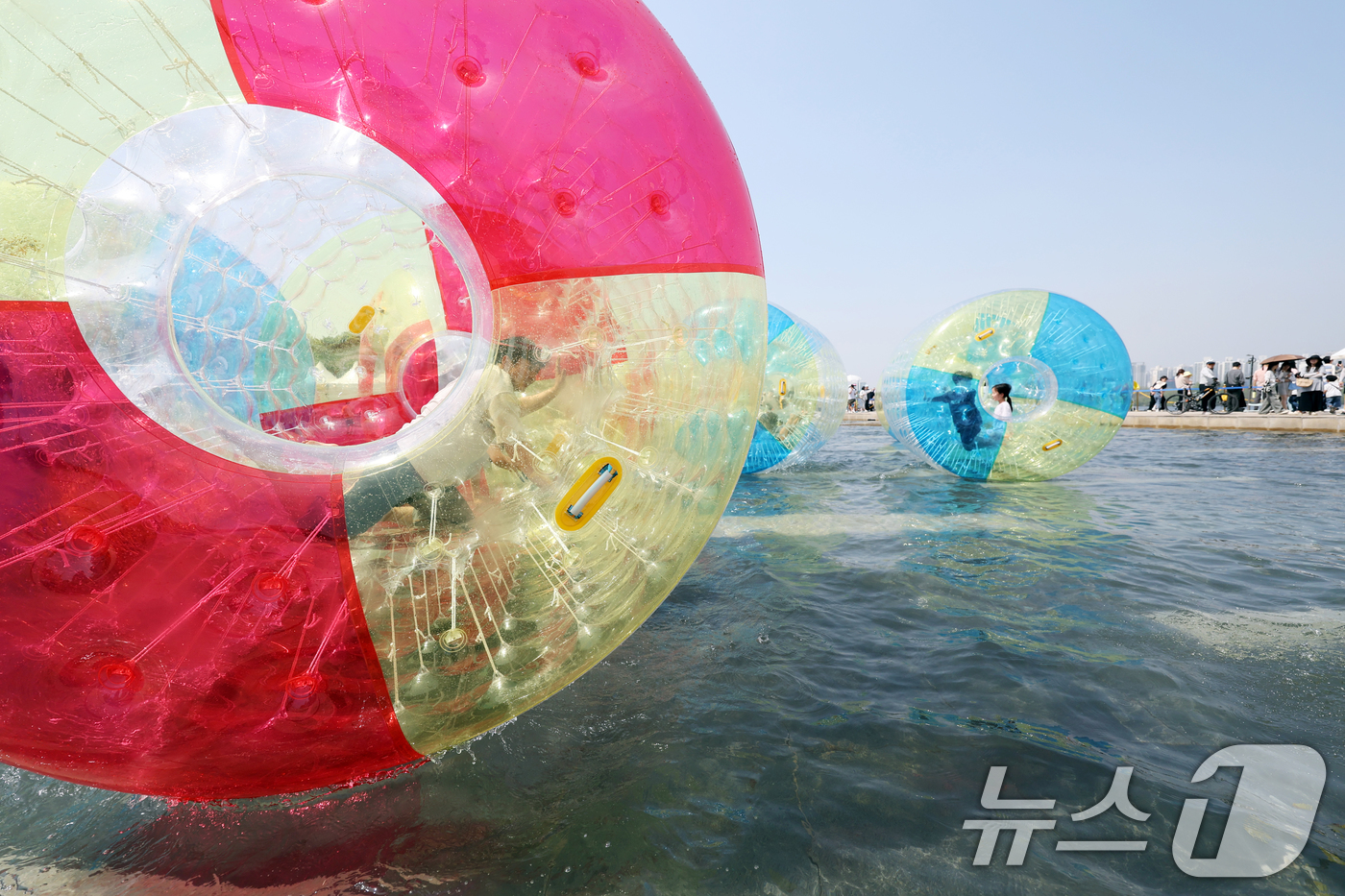 (서울=뉴스1) 황기선 기자 = 낮 기온이 전국 내륙을 중심으로 최고 29도로 치솟으며 초여름 날씨를 보인 19일 오후 서울 영등포구 여의도 한강공원 물빛광장에서 시민들이 워터볼 …