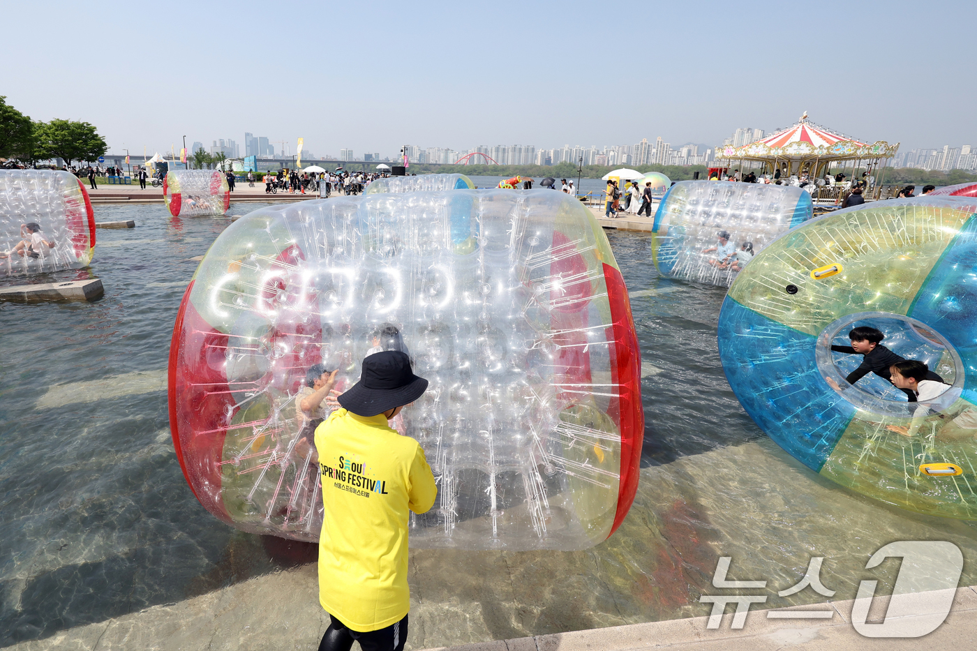 (서울=뉴스1) 황기선 기자 = 낮 기온이 전국 내륙을 중심으로 최고 29도로 치솟으며 초여름 날씨를 보인 19일 오후 서울 영등포구 여의도 한강공원 물빛광장에서 시민들이 워터볼 …