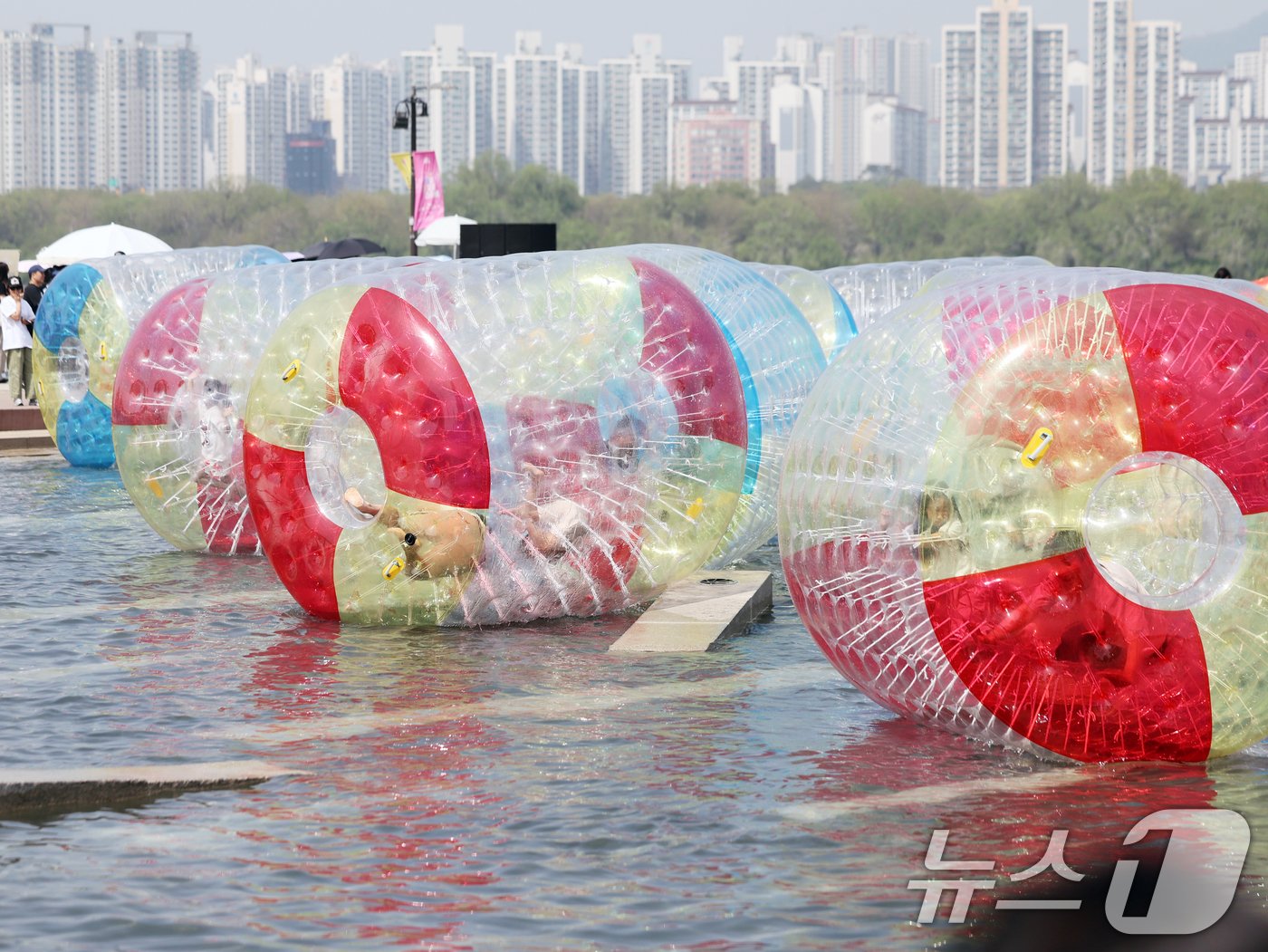 (서울=뉴스1) 황기선 기자 = 낮 기온이 전국 내륙을 중심으로 최고 29도로 치솟으며 초여름 날씨를 보인 19일 오후 서울 영등포구 여의도 한강공원 물빛광장에서 시민들이 워터볼 …