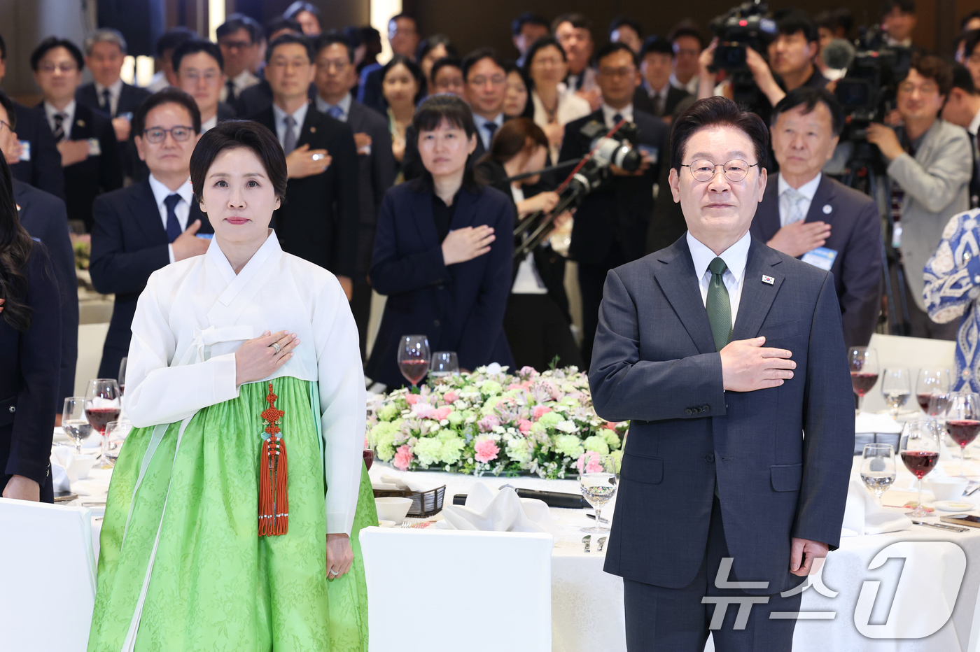 (뉴델리(인도)=뉴스1) 이재명 기자 = 인도를 국빈 방문 중인 이재명 대통령과 김혜경 여사가 19일 뉴델리의 한 호텔에서 열린 동포 만찬 간담회에서 국민의례를 하고 있다. 202 …