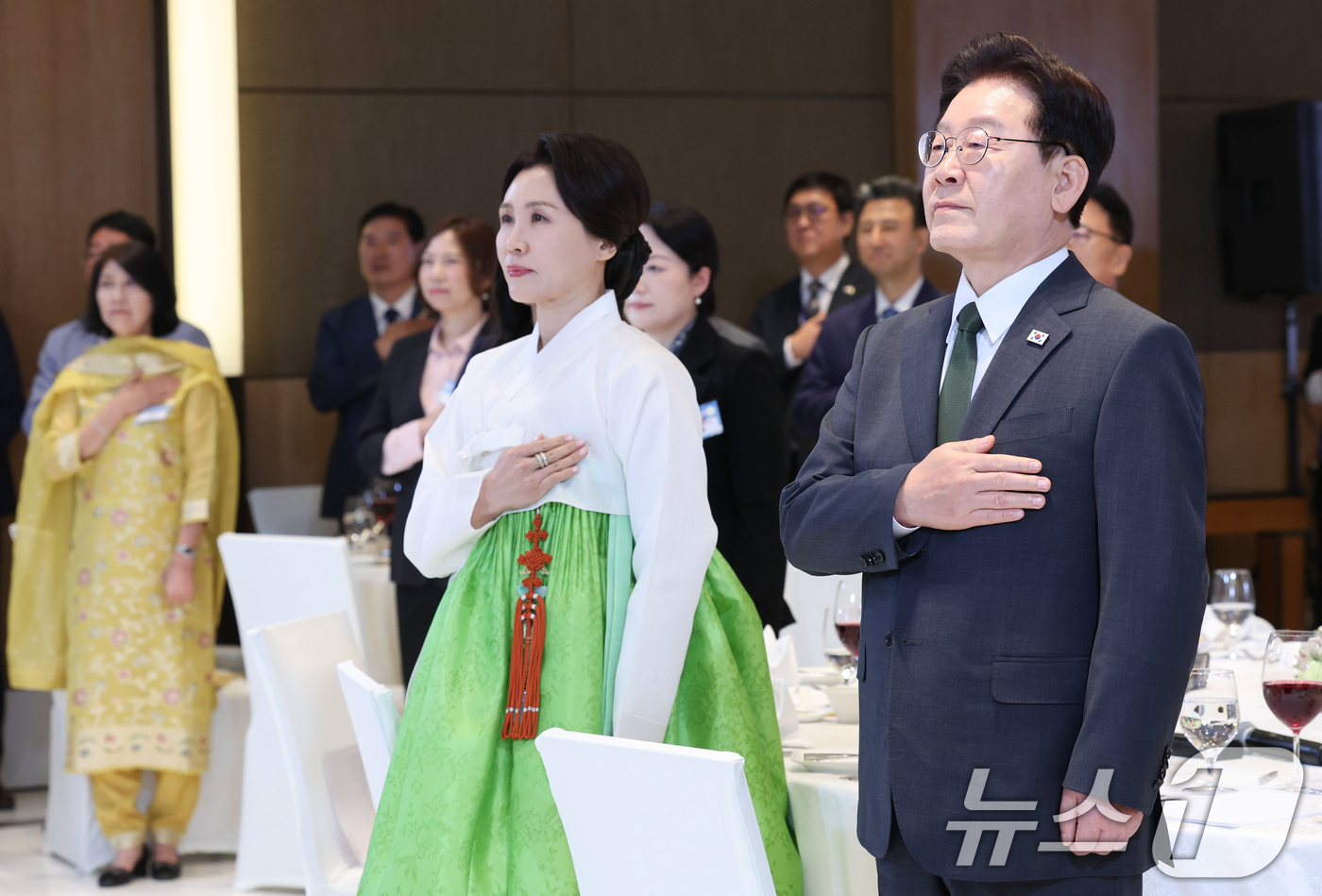 (뉴델리(인도)=뉴스1) 이재명 기자 = 인도를 국빈 방문 중인 이재명 대통령과 김혜경 여사가 19일 뉴델리의 한 호텔에서 열린 동포 만찬 간담회에서 국민의례를 하고 있다. 202 …