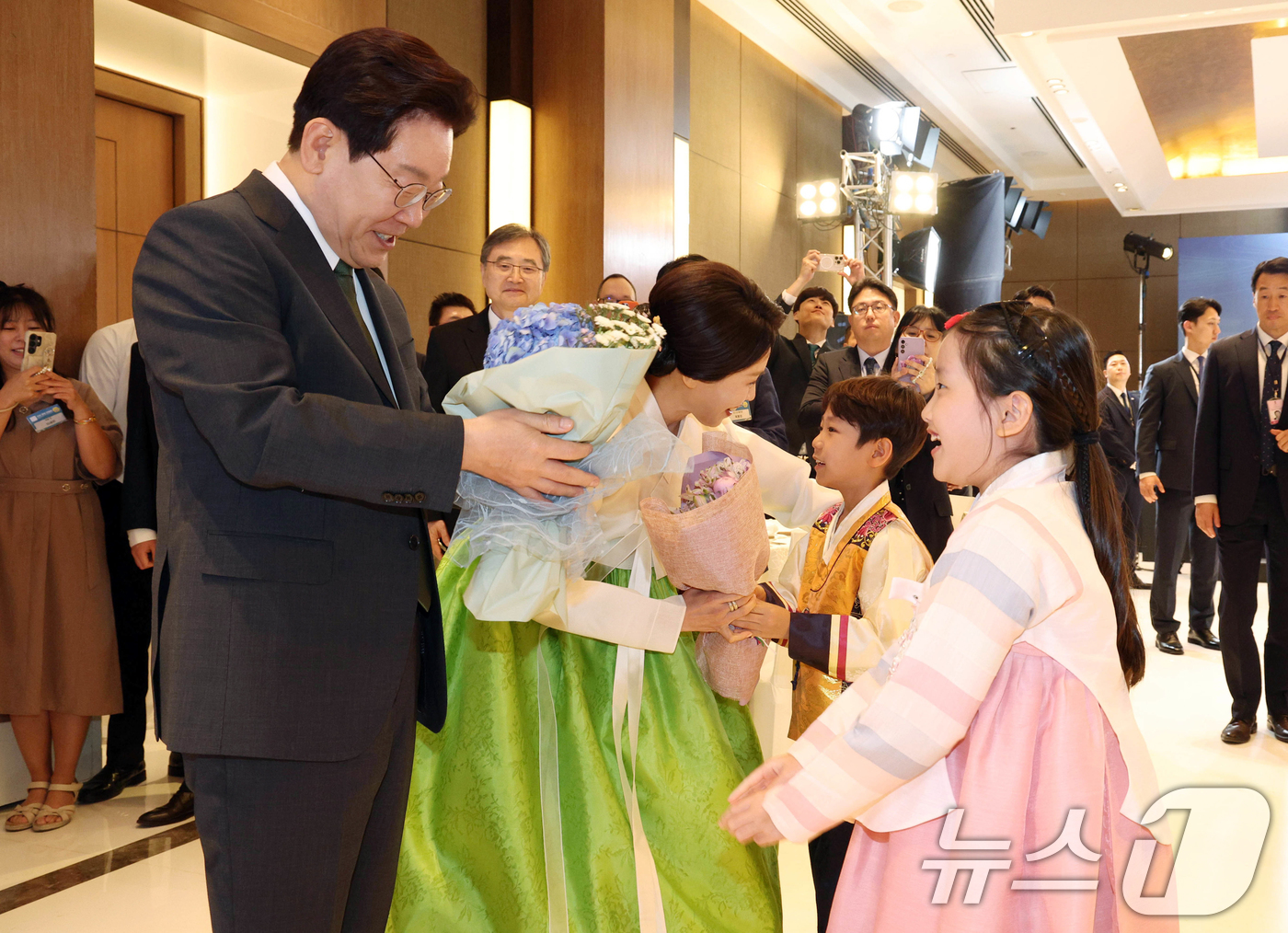 (뉴델리(인도)=뉴스1) 이재명 기자 = 인도를 국빈 방문 중인 이재명 대통령과 김혜경 여사가 19일 뉴델리의 한 호텔에서 열린 동포 만찬 간담회에서 화동에게 꽃다발을 받고 있다. …