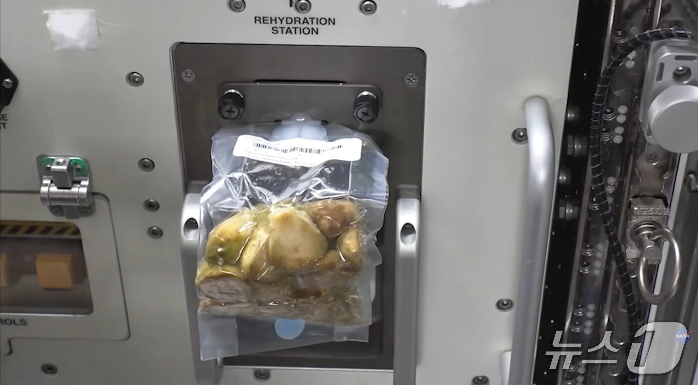본문 이미지 - 재수화 장치에서 동결건조 우주식에 물을 주입하는 모습. 우주비행사들은 이 방식으로 식사를 준비한다. (NASA 유튜브 갈무리)