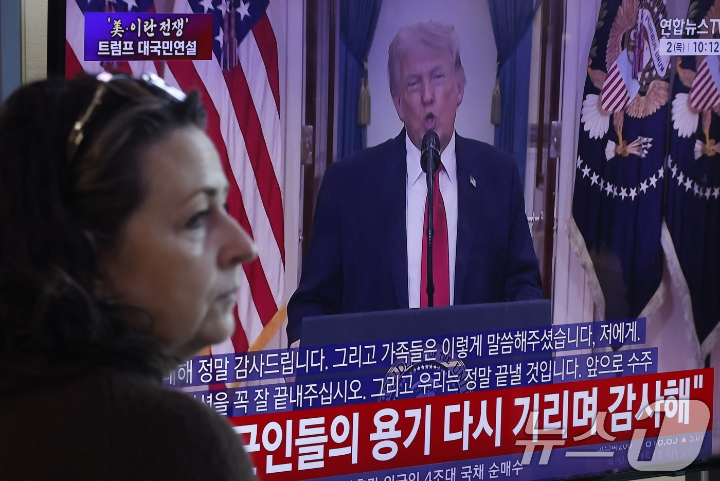 (서울=뉴스1) 박정호 기자 = 2일 오전 서울시 용산구 서울역 대합실에서 한 외국인 관광객이 도널드 트럼프 미국 대통령의 대 이란 전쟁 상황 관련 대국민 연설 TV 생중계를 지켜 …