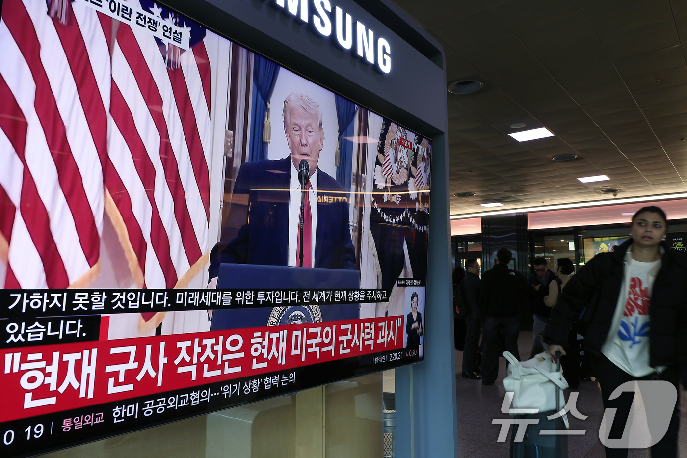 (서울=뉴스1) 박정호 기자 = 2일 오전 서울시 용산구 서울역 대합실에서 한 외국인이 도널드 트럼프 미국 대통령의 이란 전쟁 상황 관련 대국민 연설 TV 생중계를 지켜보고 있다. …