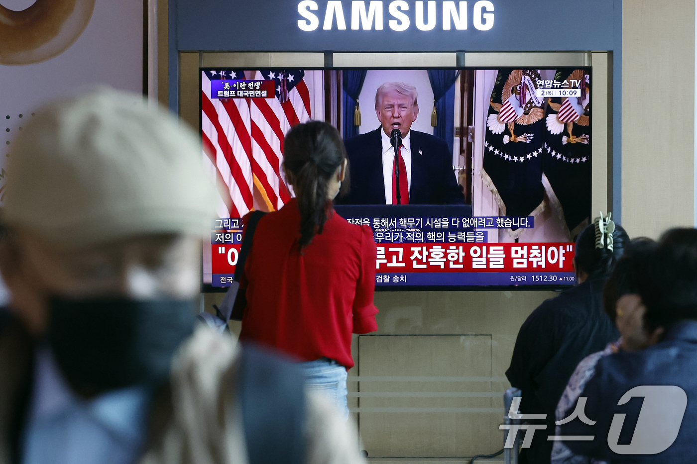 (서울=뉴스1) 박정호 기자 = 2일 오전 서울시 용산구 서울역 대합실에서 시민들이 도널드 트럼프 미국 대통령의 이란 전쟁 상황 관련 대국민 연설 TV 생중계를 지켜보고 있다. …